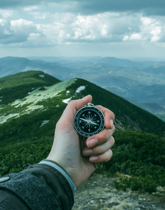 A hand holding a compass